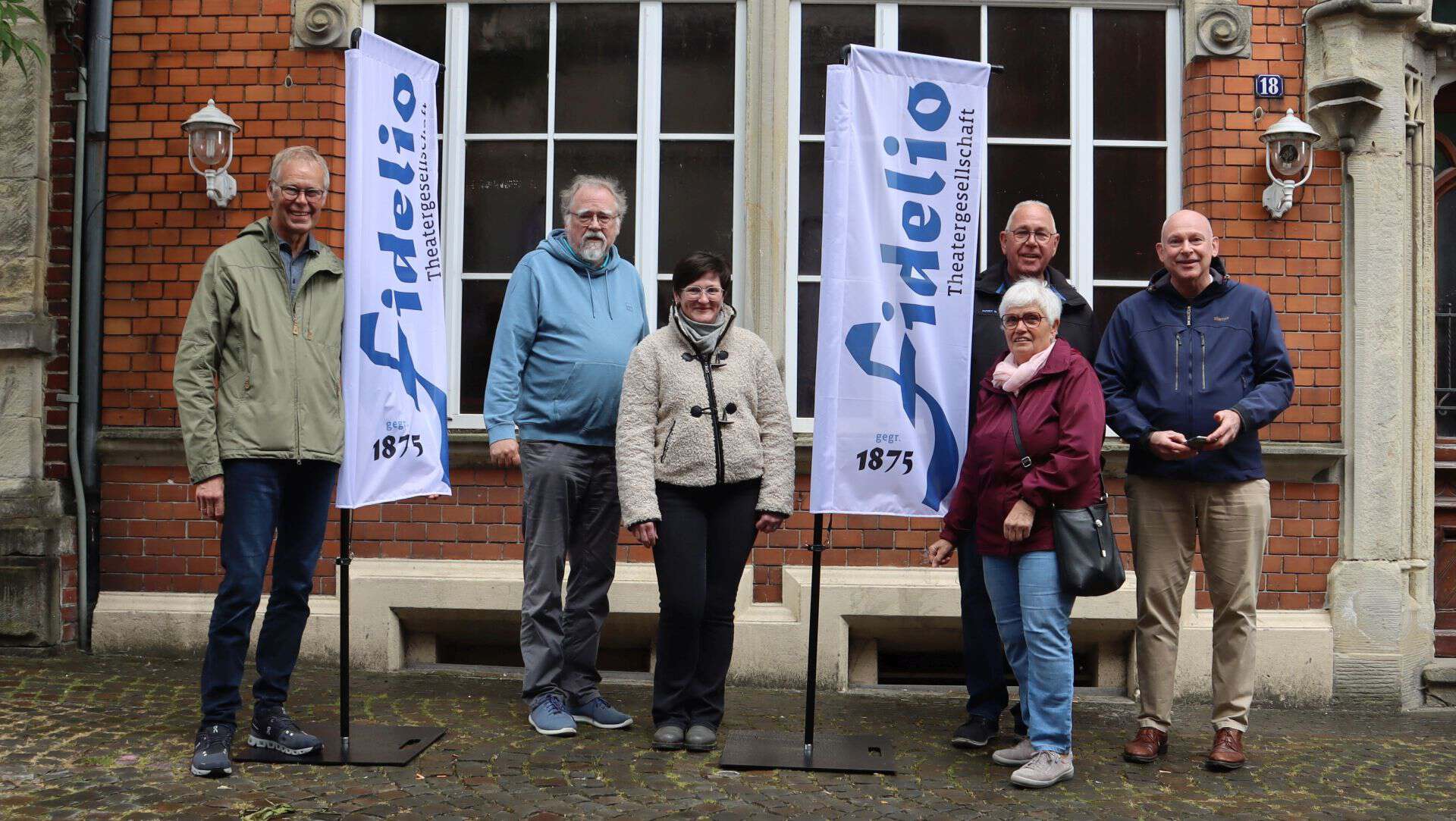 Vertreter der Theatergesellschaft Fidelio und der Bürgerstiftung präsentieren die neuen Square-Flags